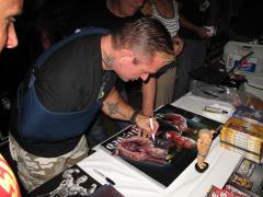 Lee using his left hand to sign photos..jpg